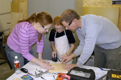 Jessica & Duane help Rebekah begin sanding her puzzle